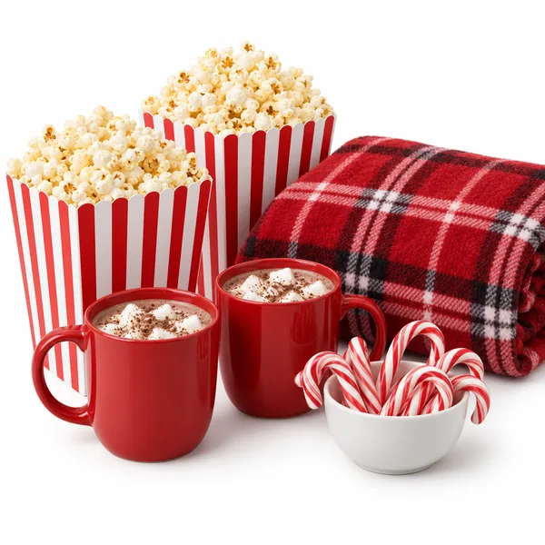 Striped popcorn buckets, a plaid blanket, mugs of cocoa and candy canes
